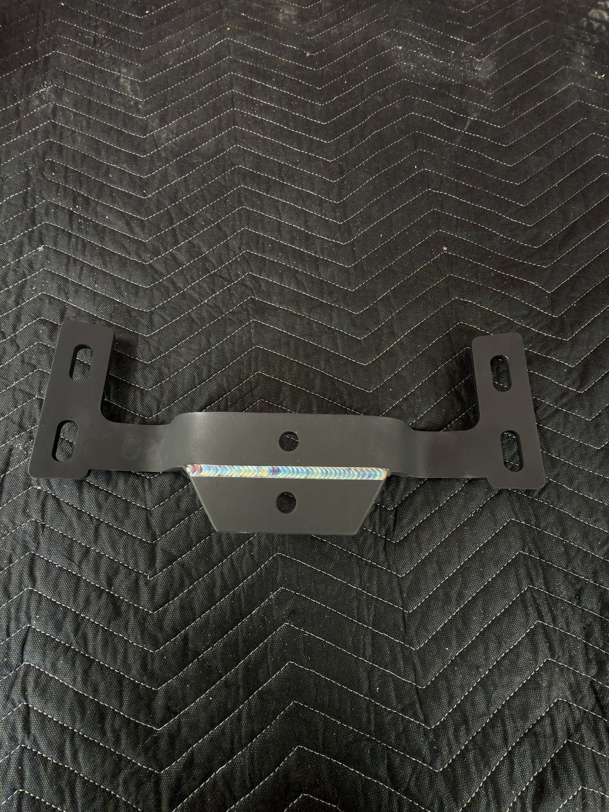 Black-coated custom steel bracket with a TIG weld along the center gusset