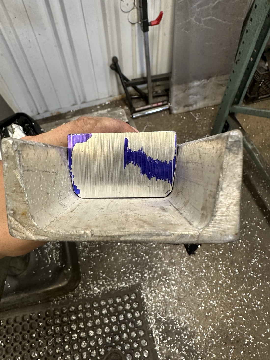 Manually machined aluminum block with chamfered edges seated snugly inside a length of C-channel