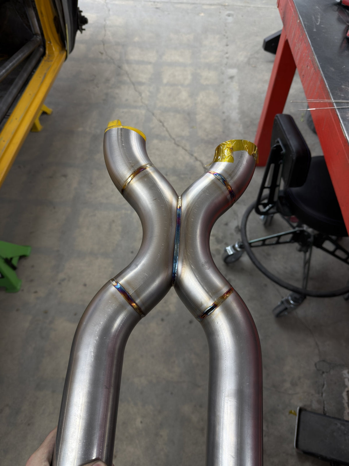 Custom stainless steel X-pipe with TIG welds showing heat-tint colors